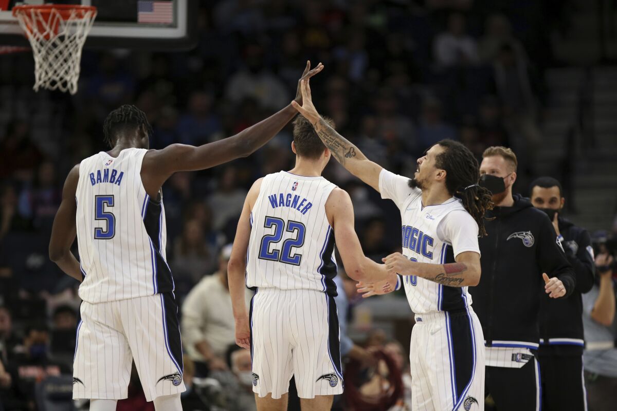 Orlando Magic's Mo Bamba (5) high fives teammate Cole Anthony (50) during the first half of an NBA basketball game against the Minnesota Timberwolves, Monday, Nov. 1, 2021, in Minneapolis. (AP Photo/Stacy Bengs)