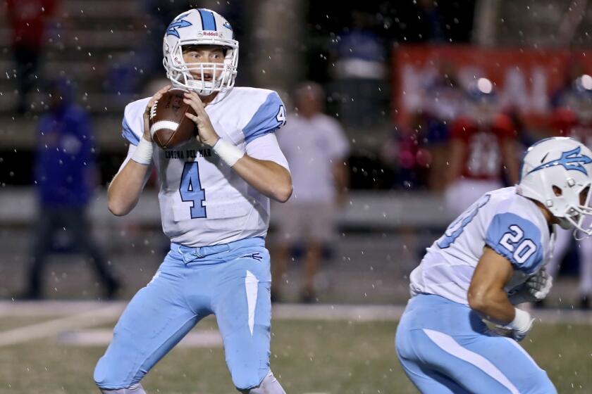Corona Del Mar football QB #4 Ethan Garbers throws the ball with rain coming down in away game vs. Los Alamitos High School, at Cerritos College in Norwalk on Friday, Oct. 12, 2018. The game was cancelled with 59 seconds left in the first quarter due to lightning.