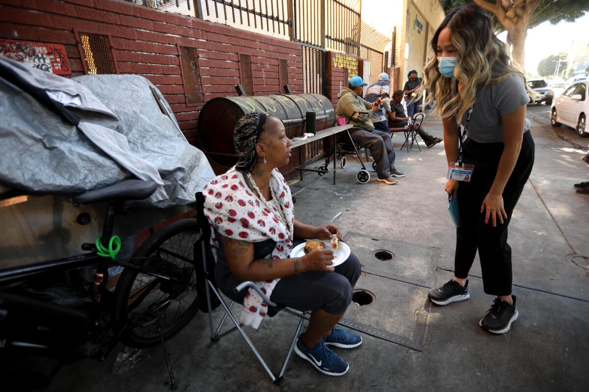 Maggie Tran speaks with a woman on Skid Row.