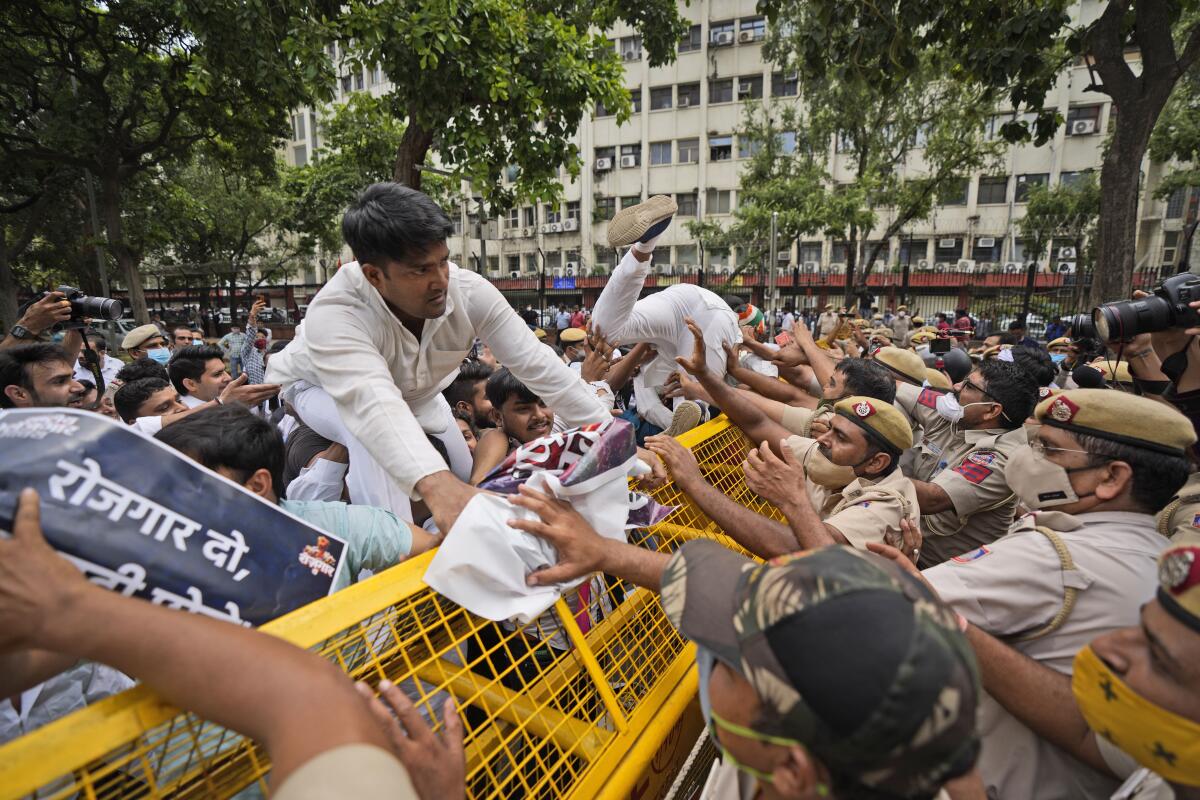 Indian Youth Congress members try to breach a police barricade during a protest held to mark Indian Prime Minister Narendra Modi's birthday in New Delhi, India, Friday, Sept.17, 2021. Youth members of main opposition Congress party clashed with police during a street protest Friday demanding jobs as the country’s economy recovered from the impact of the COVID-19 pandemic that triggered massive unemployment in the country. The march took place as supporters of Prime Minister Narendra Modi celebrated his birthday as he turned 71 on Friday. (AP Photo/Manish Swarup)