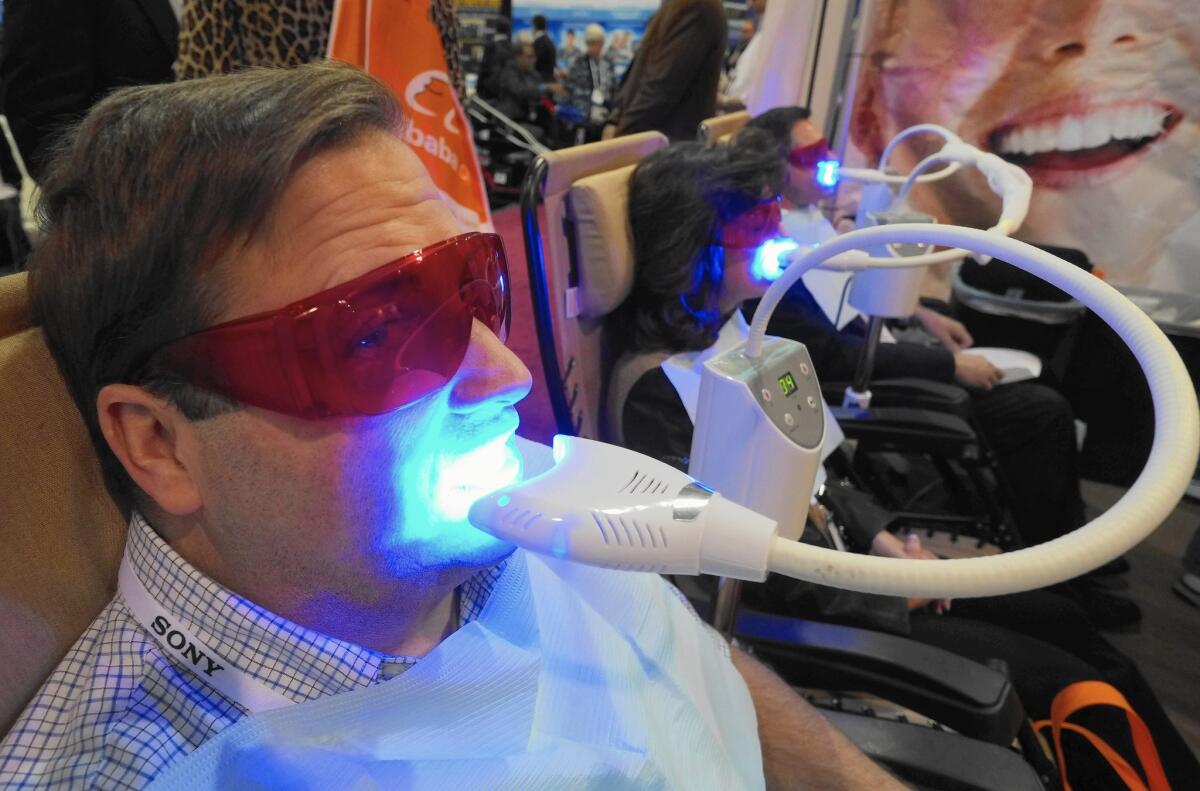 A visitor get his teeth whitened at the Consumer Electronics Show in Las Vegas in 2014. In a case that led to the Supreme Court ruling on state regulatory boards, the North Carolina dental board outlawed teeth-whitening services by nondentists.