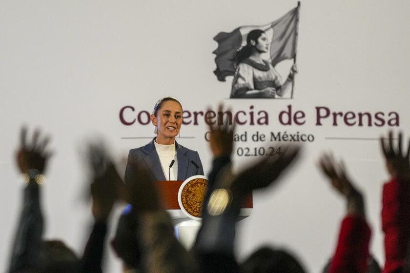 La presidenta mexicana Claudia Sheinbaum ofrece una rueda de prensa mientras los periodistas levantan la mano para hacer preguntas en el Palacio Nacional de la Ciudad de México, el miércoles 2 de octubre de 2024. (AP Foto/Fernando Llano)