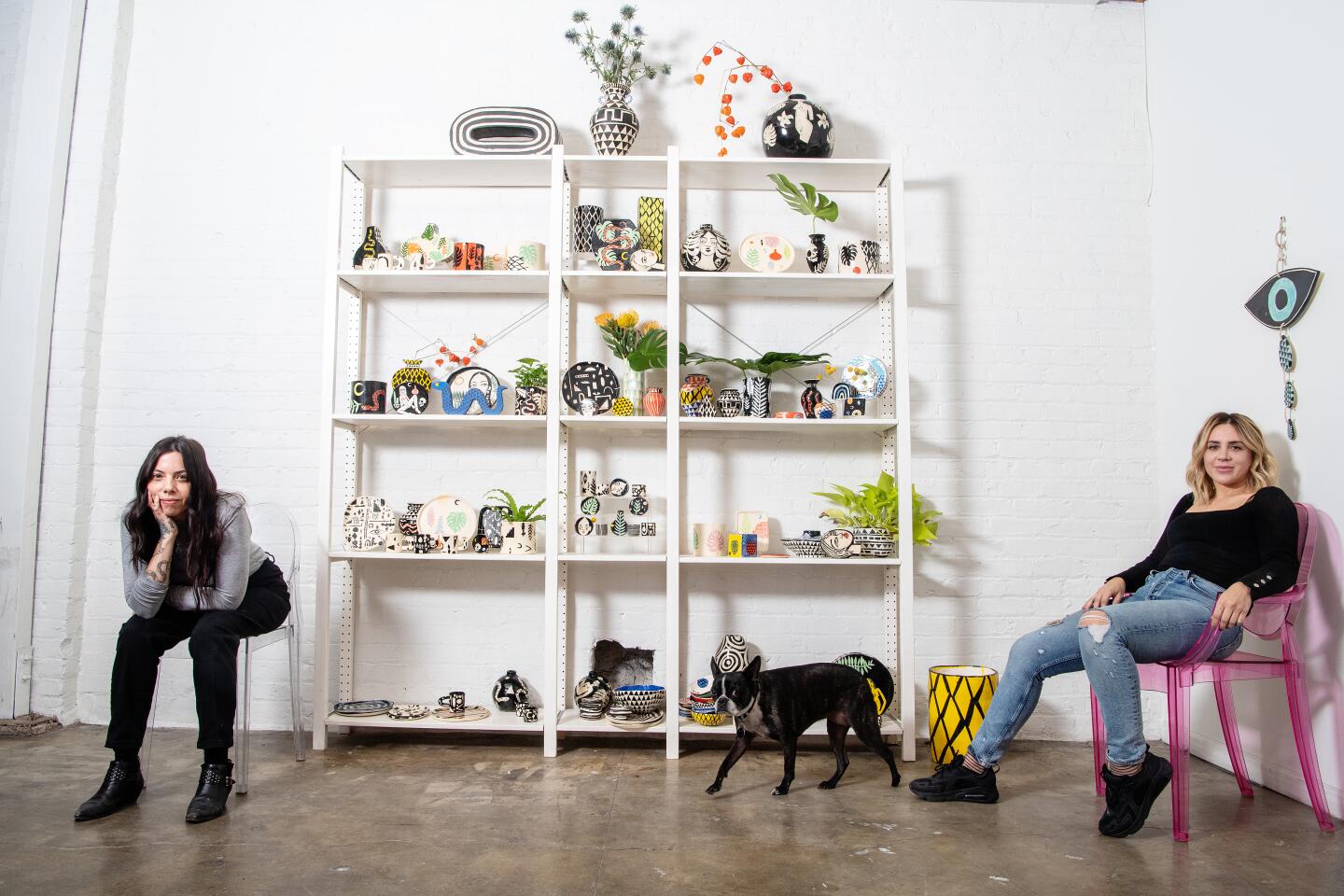 Phoebe Fisher, left, and Kristina Dove sit inside Kreep Ceramics. With them is Bijou the dog.