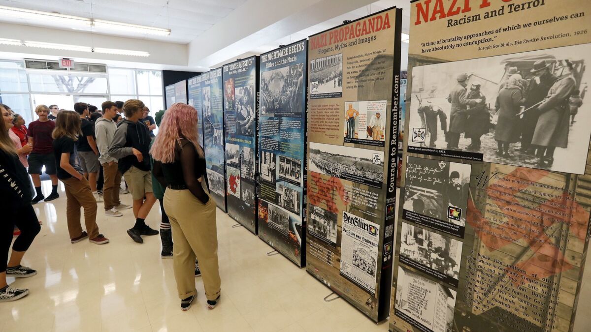 Ninth-graders visit “The Courage to Remember: The Holocaust 1933-1945” at Huntington Beach High School's Student Center on Monday. The exhibit will be open to the public Saturday.