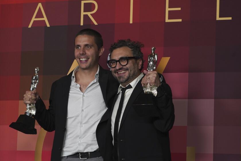 El productor David Gaitán, izquierda, y el director Alonso Ruizpalacios, con sus premios, incluyendo mejor director por "Una pelicula de policías" 64a entrega del Premio Ariel del Cine Mexicano en la Ciudad de México el 11 de octubre de 2022. (Foto AP/Marco Ugarte)