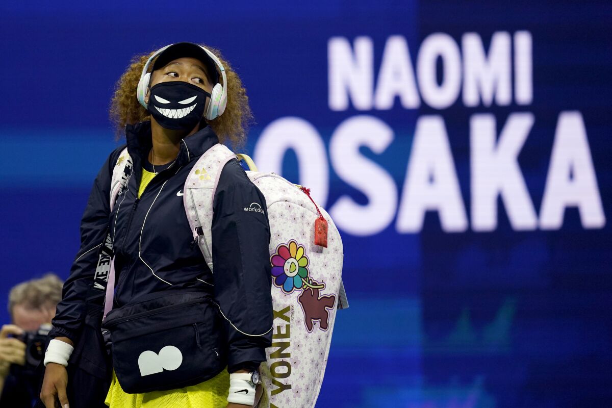 Naomi Osaka walks onto the court for her first-round U.S. Open match against Marie Bouzkova on Monday in New York. 