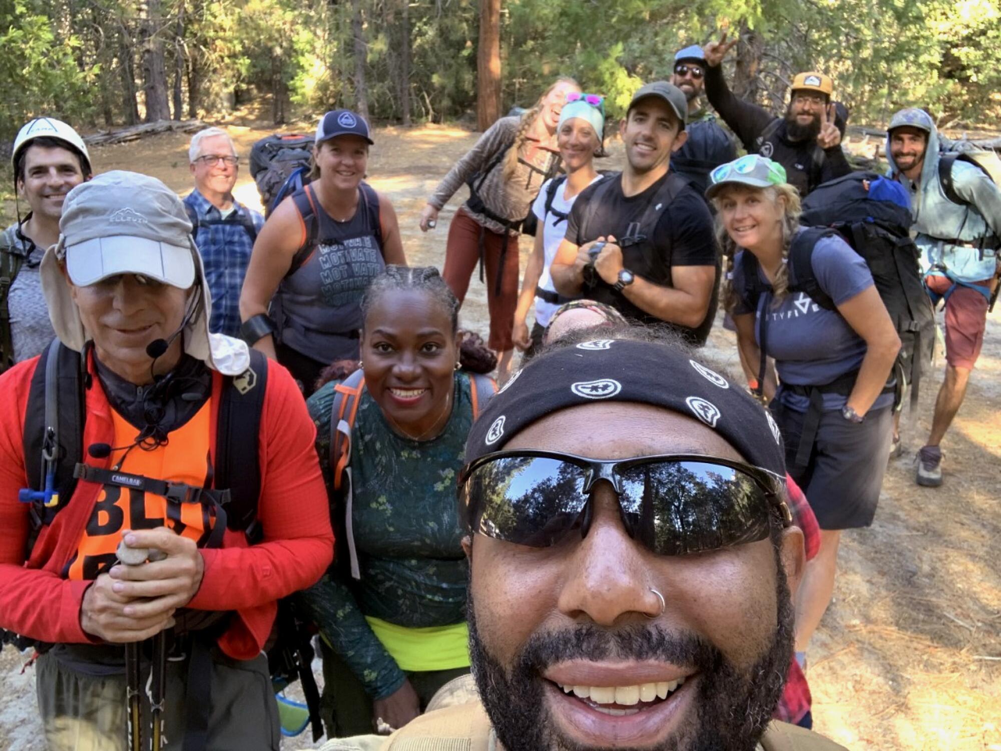 A gathering of people outdoors taking a selfie.