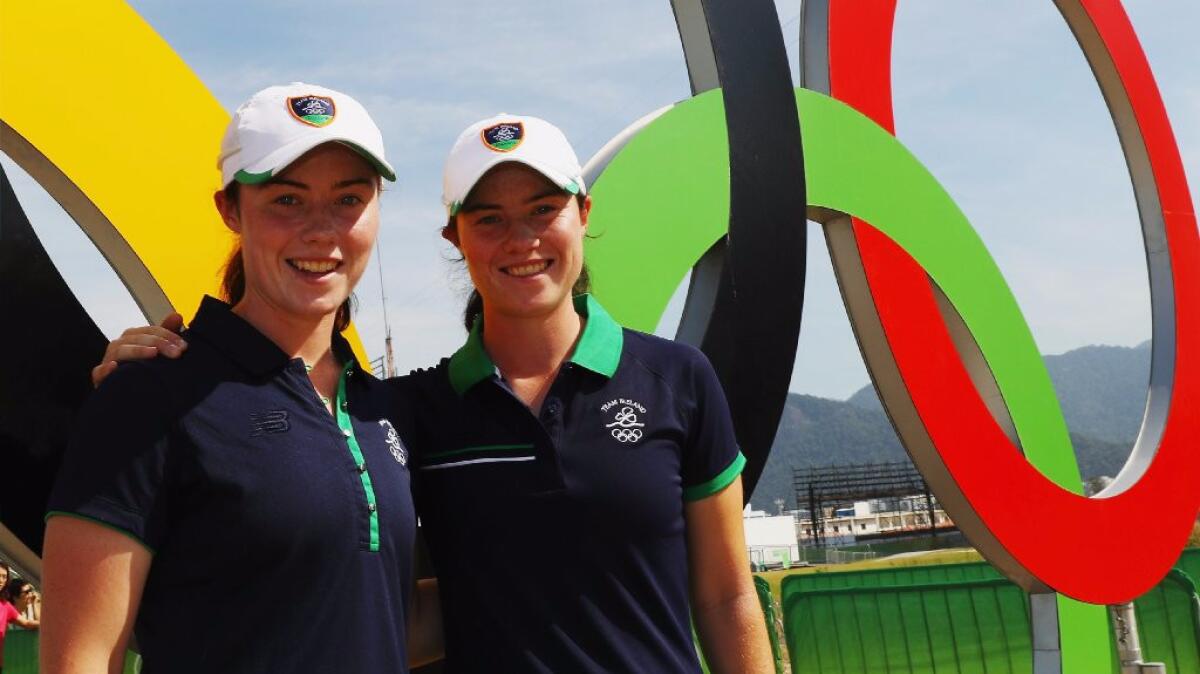 Sisters Lisa and Leona Maguire, right, of Ireland pose near a set of Olympic rings during a practice round on Aug. 16. Lisa is caddying for Leona this week.