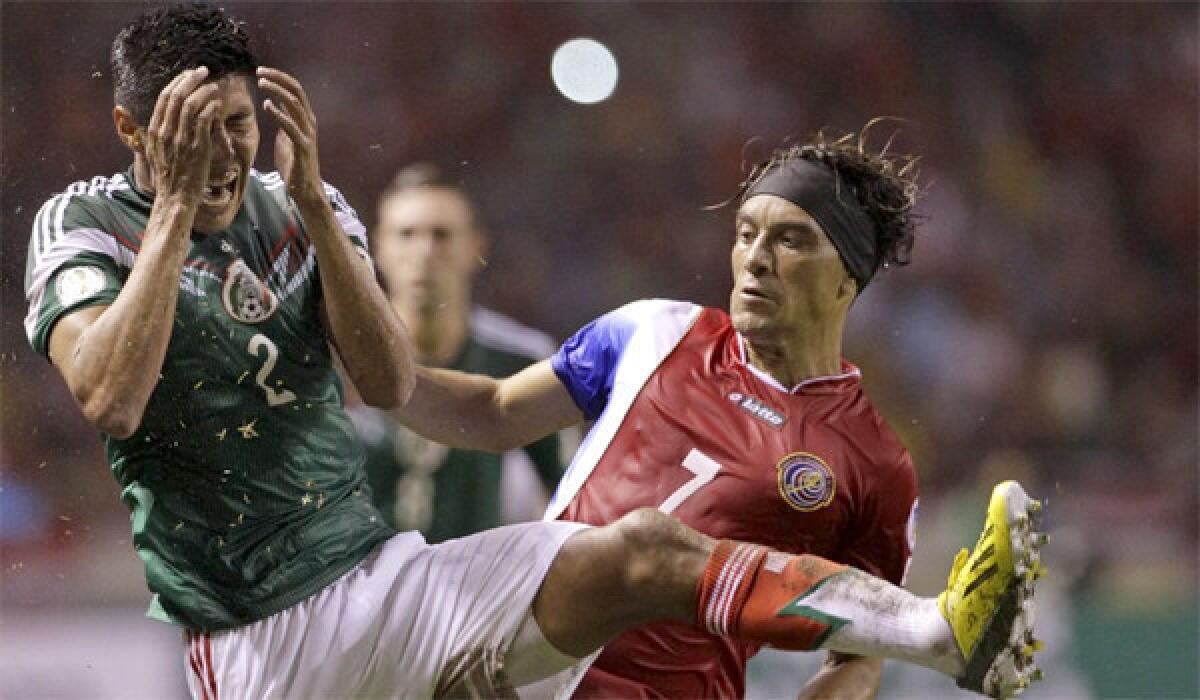 Mexico's Hugo Ayala grimaces while fighting for the ball with Costa Rica's Christian Bolanos during Mexico's 2-1 loss to Costa Rica during a World Cup qualifying match on Oct. 15.