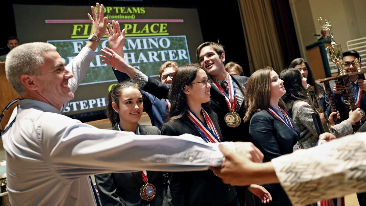 El Camino Real Charter High School students celebrate with Principal David Hussey, left, after winning L.A. Unified's Academic Decathlon competition in February.