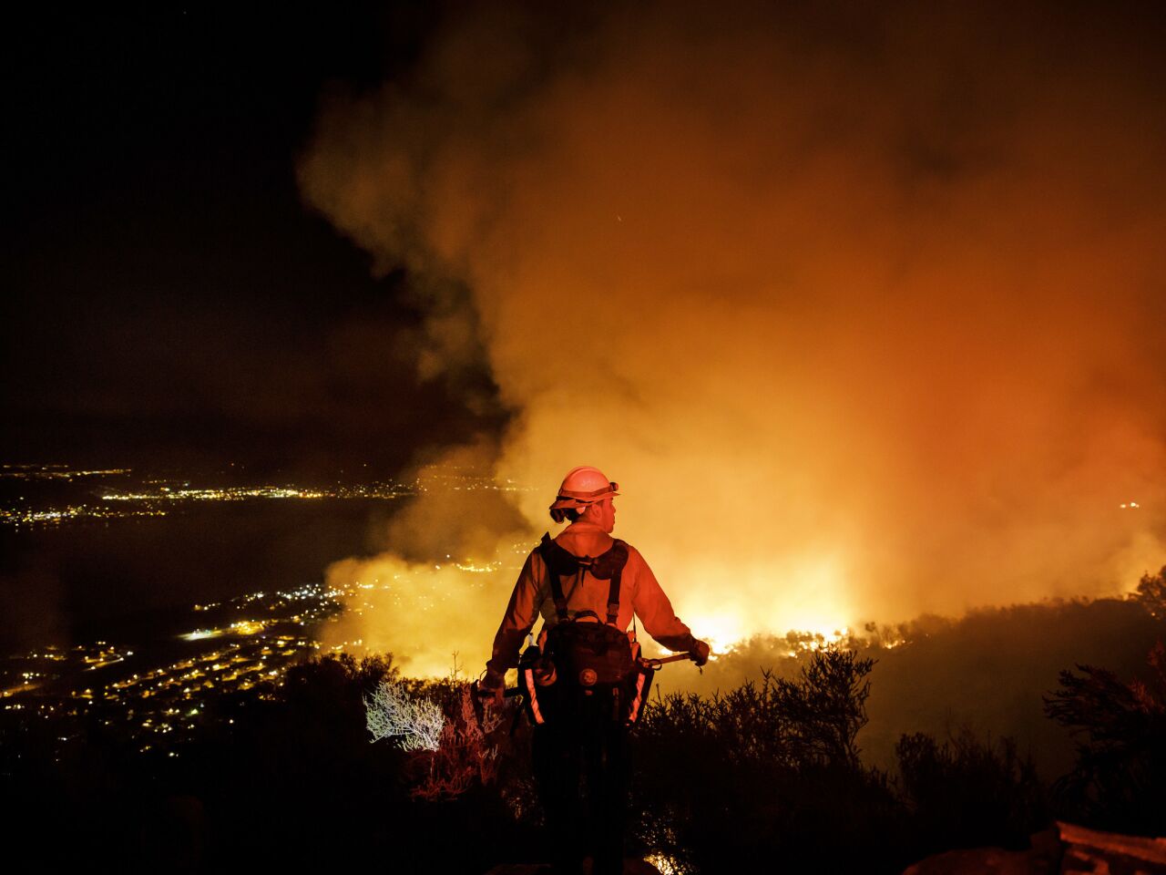 Firefighters watch for flareups as they prevent the flames from the Holy fire from crossing the Ortega Highway in Lake Elsinore.