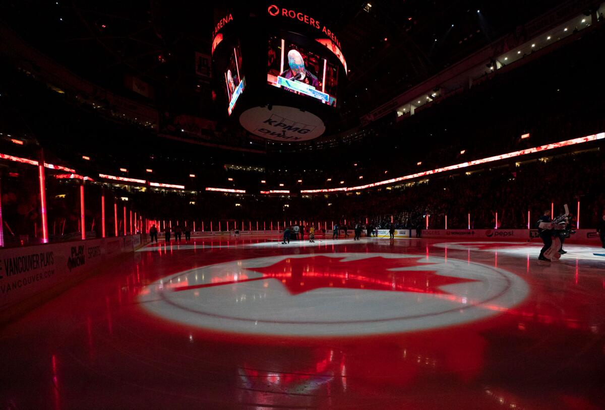 A maple leaf is projected on the ice during the singing of the Canadian national anthem at Rogers Arena in Vancouver.