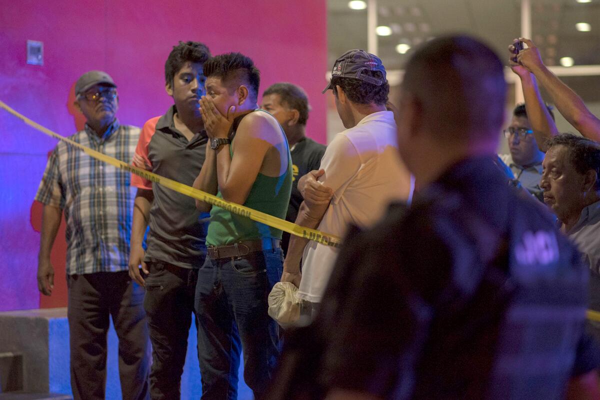 People gather near a nightclub in Coatzacoalcos, Mexico, on Aug. 28, waiting for information after an armed gang stormed the nightclub in a rampage that killed 25 people and injured more than a dozen others.