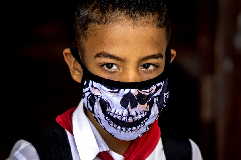 CUBA: A student wears a face mask as a precaution against the spread of the new coronavirus, as he walks after school was let out for the day in Havana, Cuba.