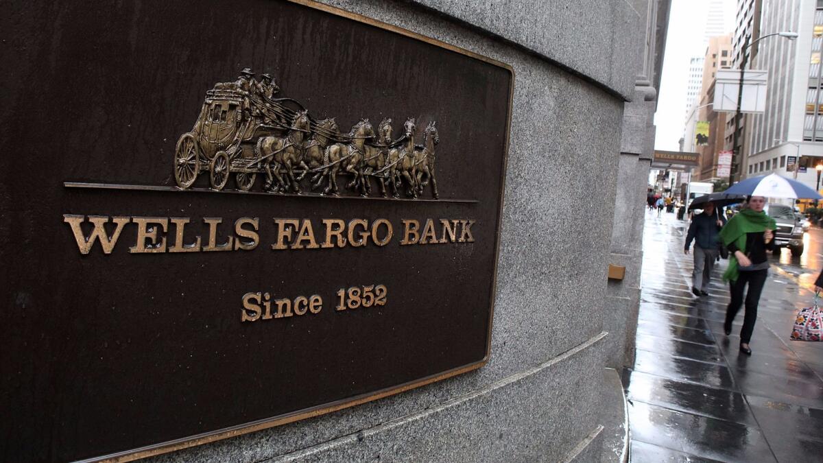 Pedestrians walk by a Wells Fargo Bank branch office in San Francisco.