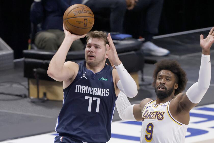 The Mavericks' Luka Doncic shoots as the Lakers' Wesley Matthews defends during the first half April 24, 2021.