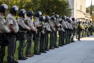 RIVERSIDE, CA - NOVEMBER 4, 2020: Riverside County Sheriff Deputies stand guard at the historic county courthouse as demonstrators gather in support of "Counting Every Vote" and democracy on November 4, 2020 in Riverside, California. (Gina Ferazzi / Los Angeles Times)