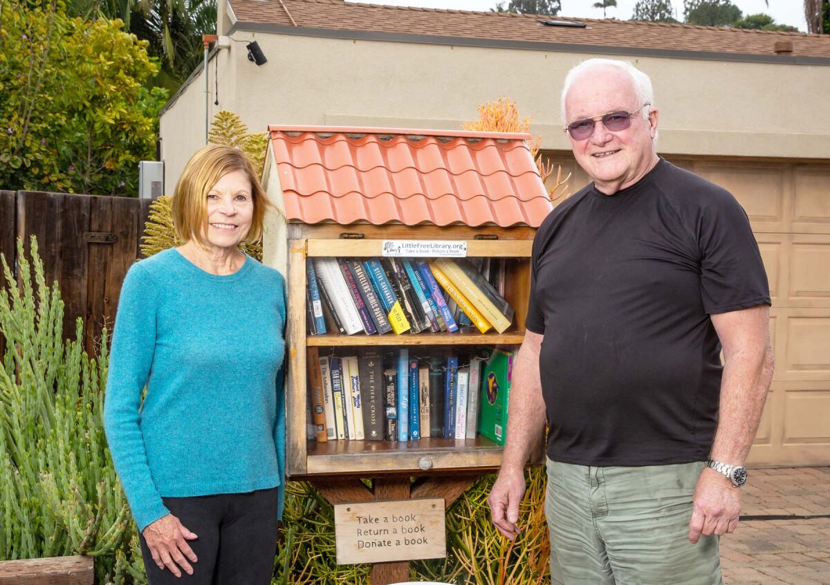 Andrea and John McCarren with their Little Free Library at 5298 Edgeworth Road.