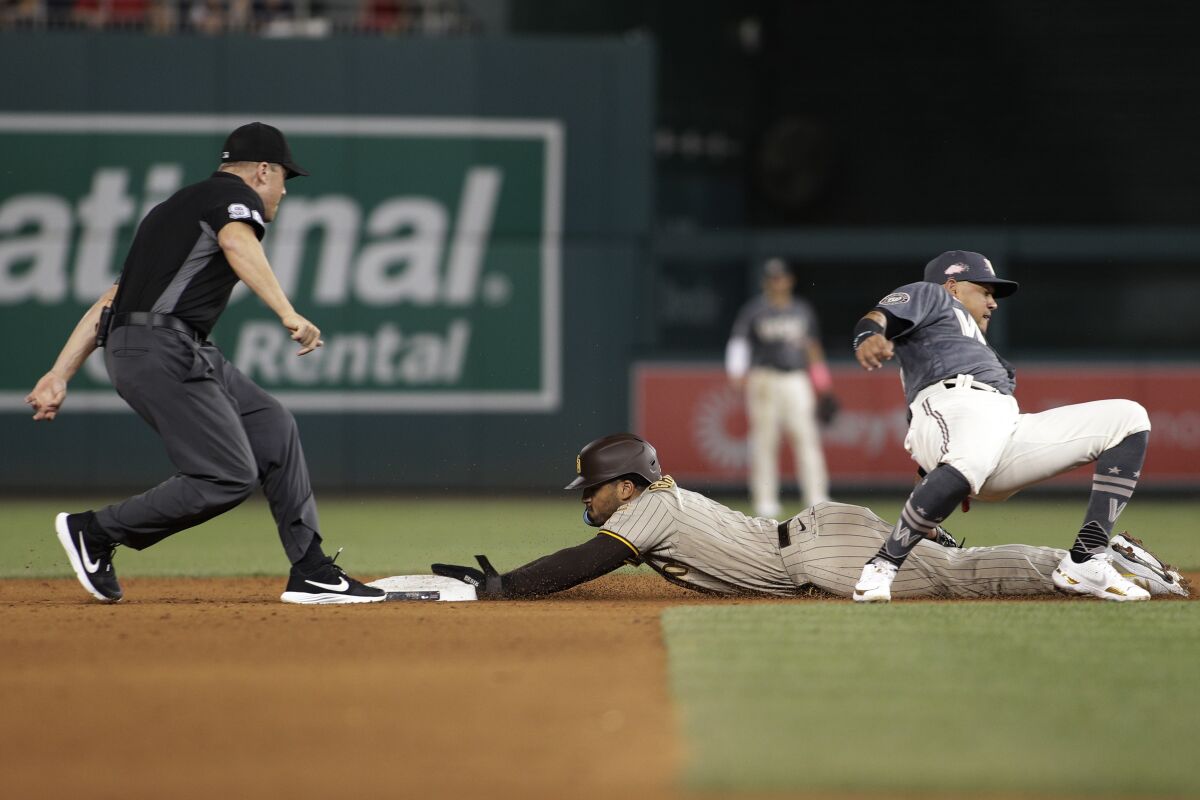 The Padres' Trent Grisham steals second base as Nationals shortstop Ildemaro Vargas, right, attempts a tag 