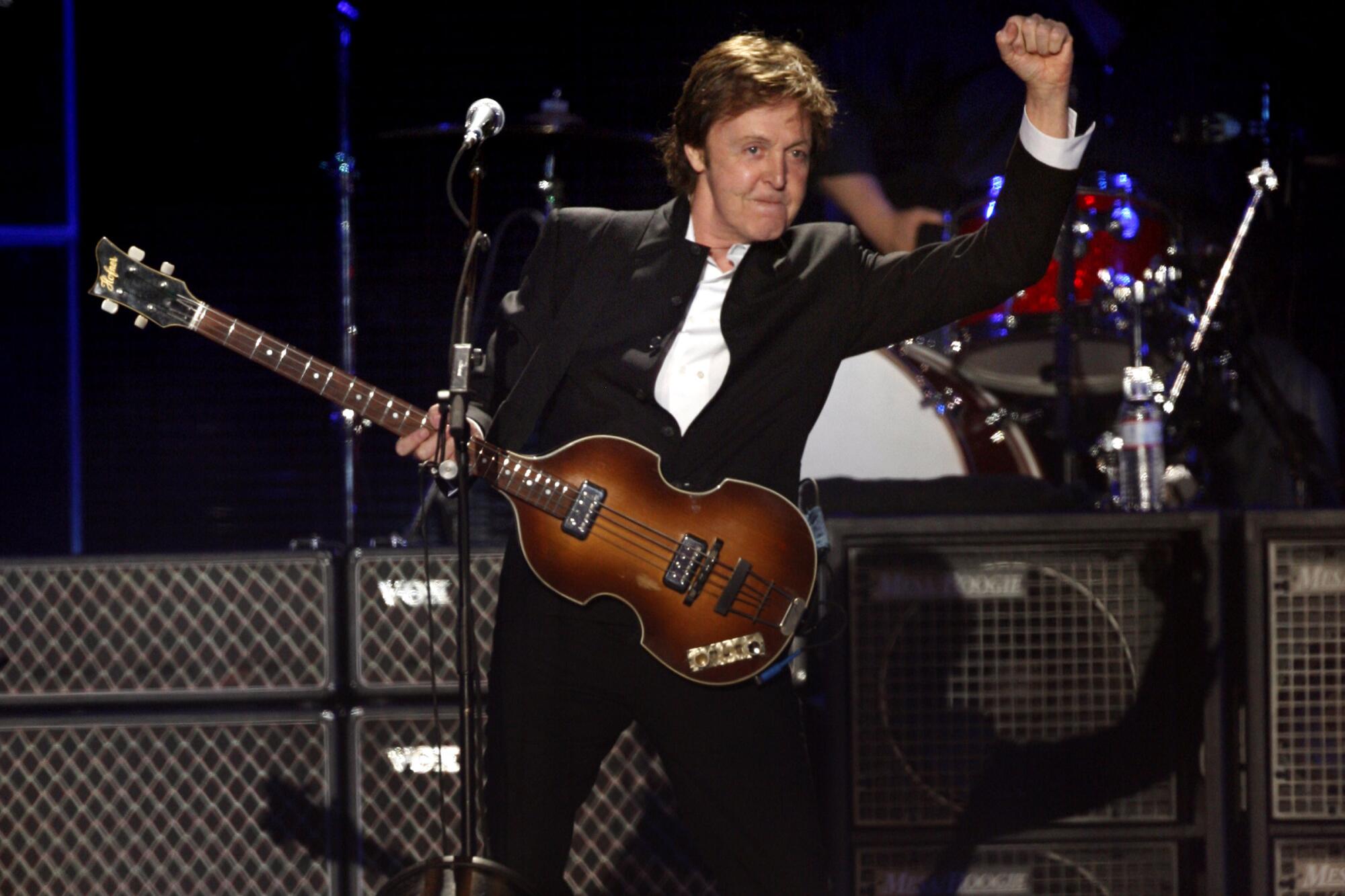 Paul McCartney connected  signifier    with his bass and a fist successful  the air
