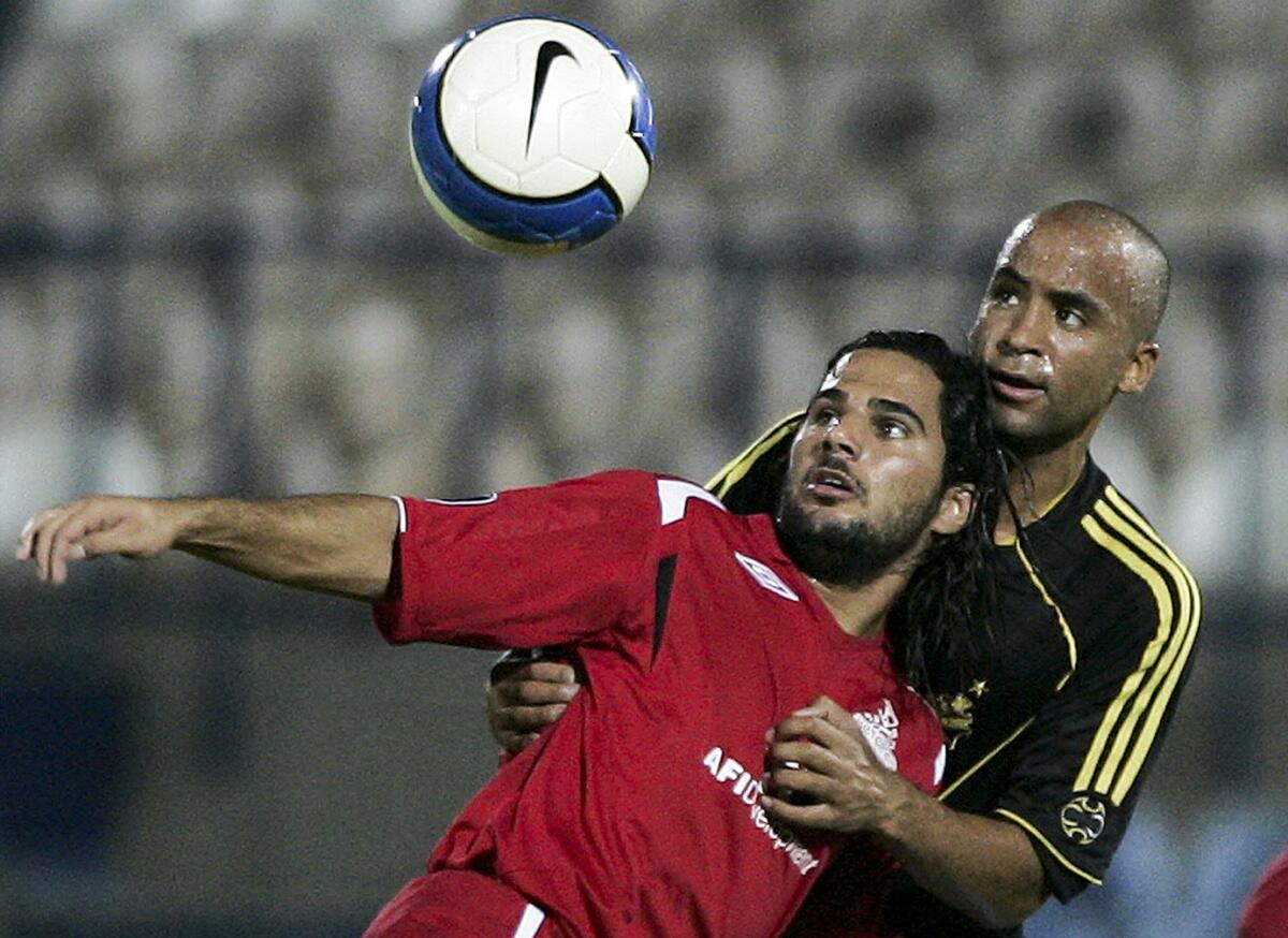 Hapoel Tel Aviv's Lior Asulin vies for the ball with AIK Solna's Jimmy Tamadi during a soccer match.