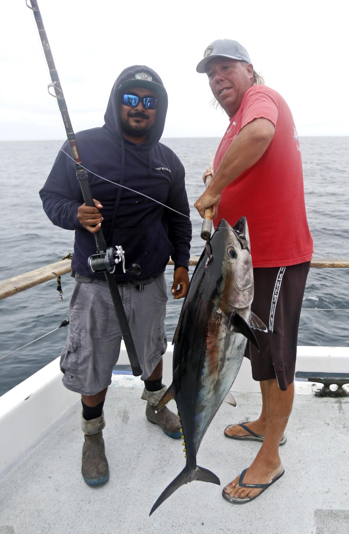 Angler Gustavo Zamora, 32 of Rialto, left, stands with boat captain Paul Hansen and the Bluefin tuna Zamora caught.