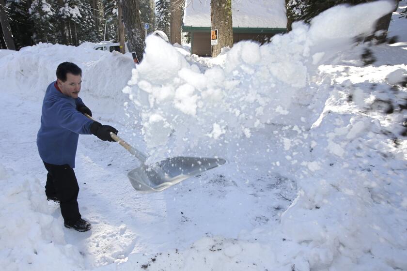 John Mamola shovels snow from the driveway leading to his cabin near Echo Summit, Calif., last month.