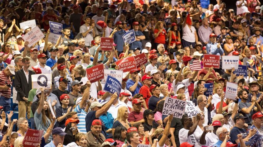 A "Q" sign, for "QAnon," is raised in the crowd at President Trump's rally July 31 at the Florida State Fairgrounds Expo Hall in Tampa.
