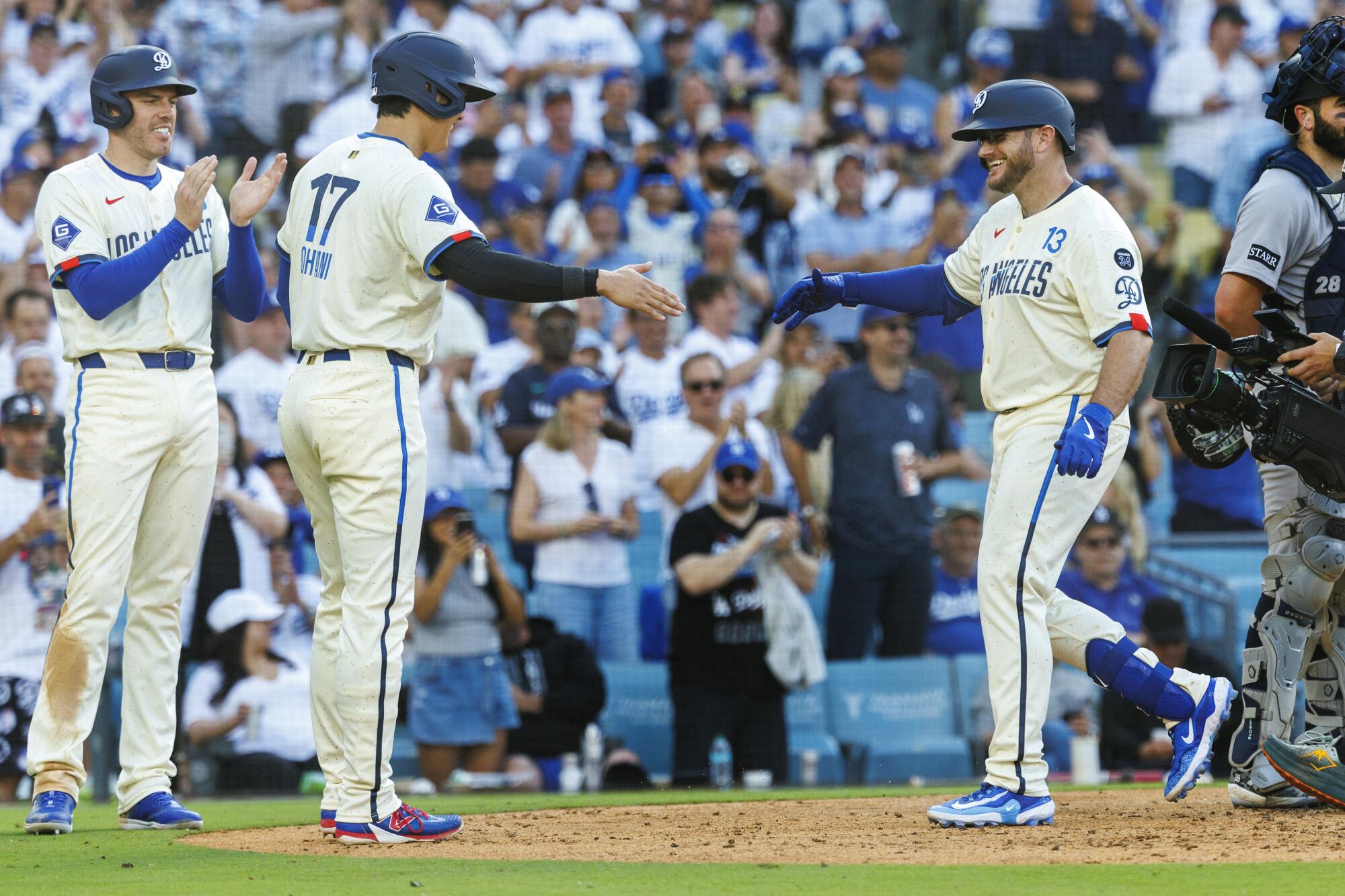 Max Muncy, right, celebrates with Shohei Ohtani, center, and Freddie Freeman after hitting a three-run home run.