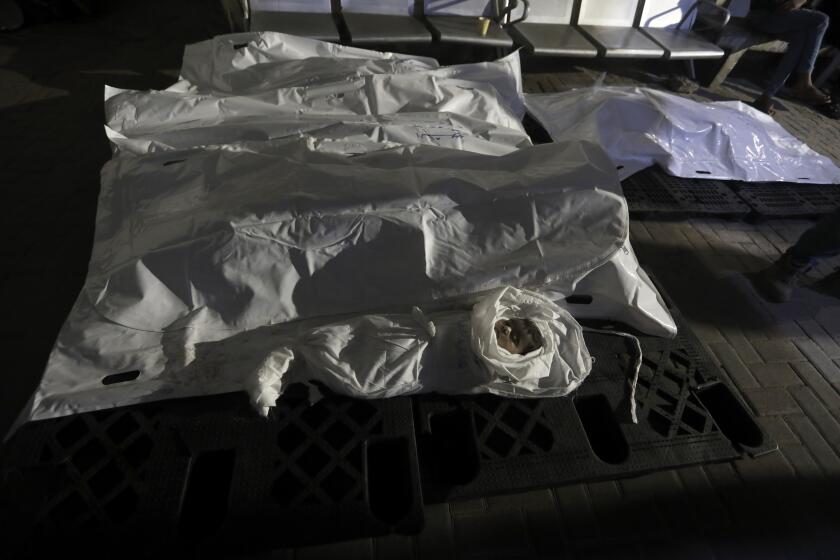 The Qeshta family is seen in body bags at the morgue of Al Najjar hospital in Rafah, southern Gaza Strip, Sunday, May 5, 2024. The family was killed in an Israeli bombardment on a residential building in Rafah. (AP Photo/Ismael Abu Dayyah)