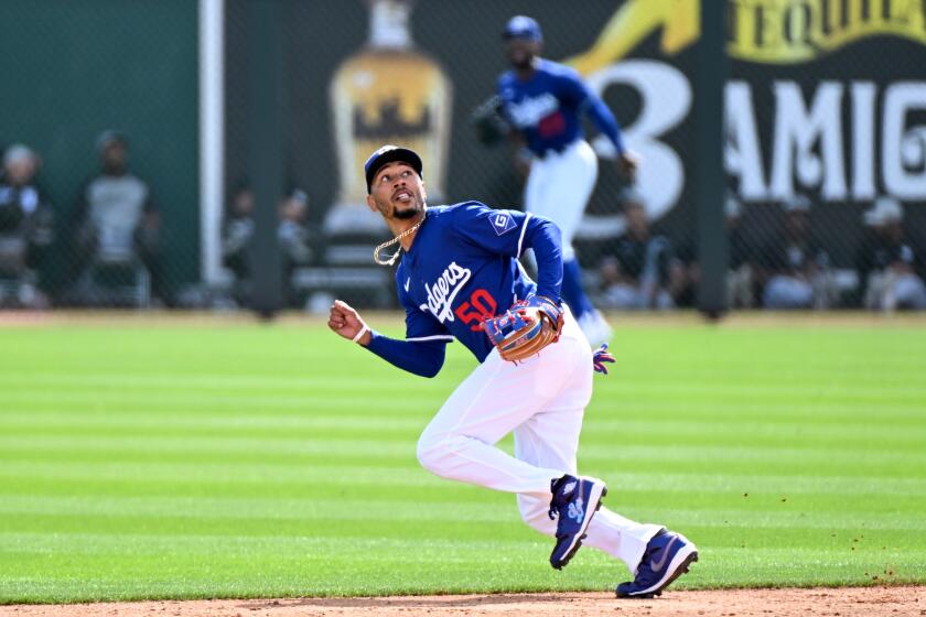 The Dodgers' Mookie Betts fields a fly ball during a spring training game against the Chicago White Sox 