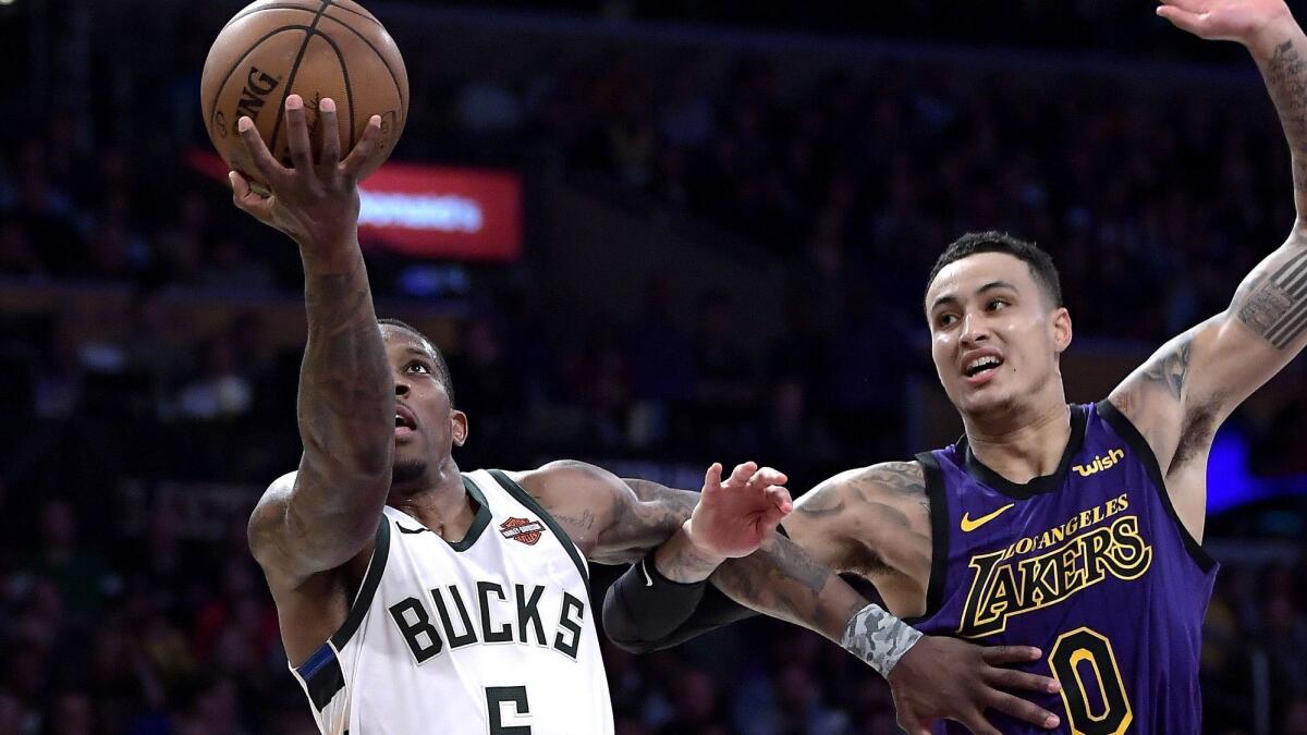 Milwaukee Bucks guard Eric Bledsoe, left, shoots as Los Angeles Lakers forward Kyle Kuzma defends during the second half of a game March 1 in Los Angeles. The Bucks won 131-120.