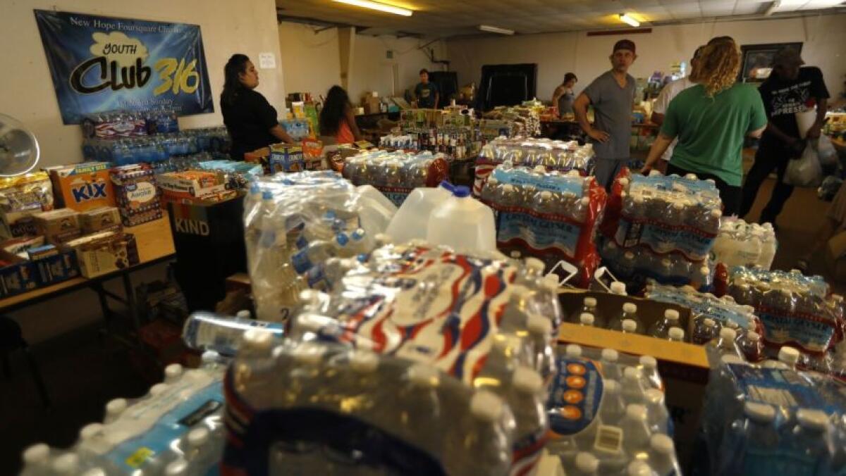 Voluntarios en una iglesia de Trona, California, distribuyen donaciones de alimentos y agua aproximadamente una semana después de un terremoto de magnitud 7.1. (Genaro Molina / Los Angeles Times)