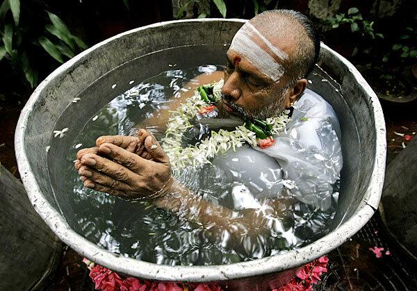 A Hindu holy man performs the Varuna Yajna ritual to appease the rain god in Mumbai, India. Priests stood neck-deep in water for more than four hours praying for the arrival of rain.