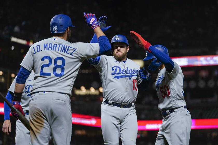 Los Angeles Dodgers' Max Muncy, middle, celebrates with teammates after hitting a three-run home run against the San Francisco Giants during the sixth inning of a baseball game in San Francisco, Wednesday, April 12, 2023. (AP Photo/Godofredo A. Vásquez)