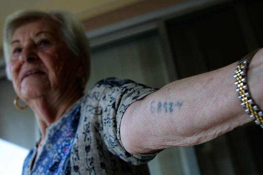 Rose Schindler holds up the identification number tattooed by Nazis upon her arrival at Auschwitz in 1944. She expresses a responsibility to accept speaking invitations because “somebody has to do it.”