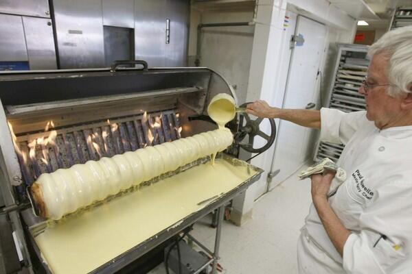 Making baumkuchen -- a German specialty cake -- is both an art and science. Here, Paul Gauweiler pours batter into a baumkuchen machine at the Cake Box in Huntington Beach. The machine is one of only three existing baumkuchen ovens in the U.S. What follows is a behind-the-scenes look at Gauweiler and his wife, Irene, at work.