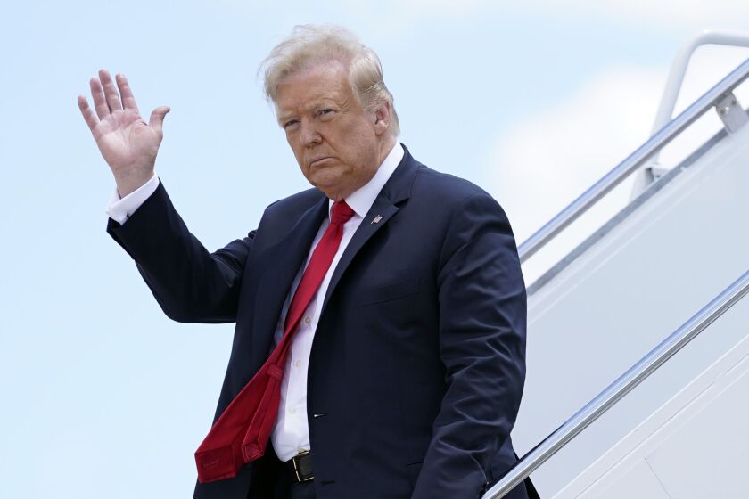 ADDS THAT IRNA IS STATE-RUN: FILE - In this Thursday, June 25, 2020 file photo, President Donald Trump waves as he arrives on Air Force One at Austin Straubel International Airport in Green Bay, Wis. Iran has issued an arrest warrant and asked Interpol for help in detaining President Donald Trump and dozens of others it believes carried out the drone strike that killed a top Iranian general in Baghdad early this year. That's according to a prosecutor in Tehran who was quoted by to state-run IRNA news agency on Monday, June 29, 2020. The prosecutor said Iran had asked Interpol to issue a “red notice” for Trump and over 30 others. (AP Photo/Evan Vucci, File)