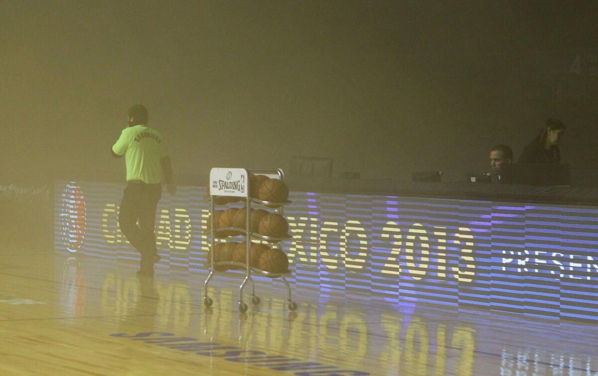 Smoke engulfs a Mexico City arena prior to the scheduled tipoff between the San Antonio Spurs and Minnesota Timberwolves on Wednesday. The arena was evacuated and the game was postponed.