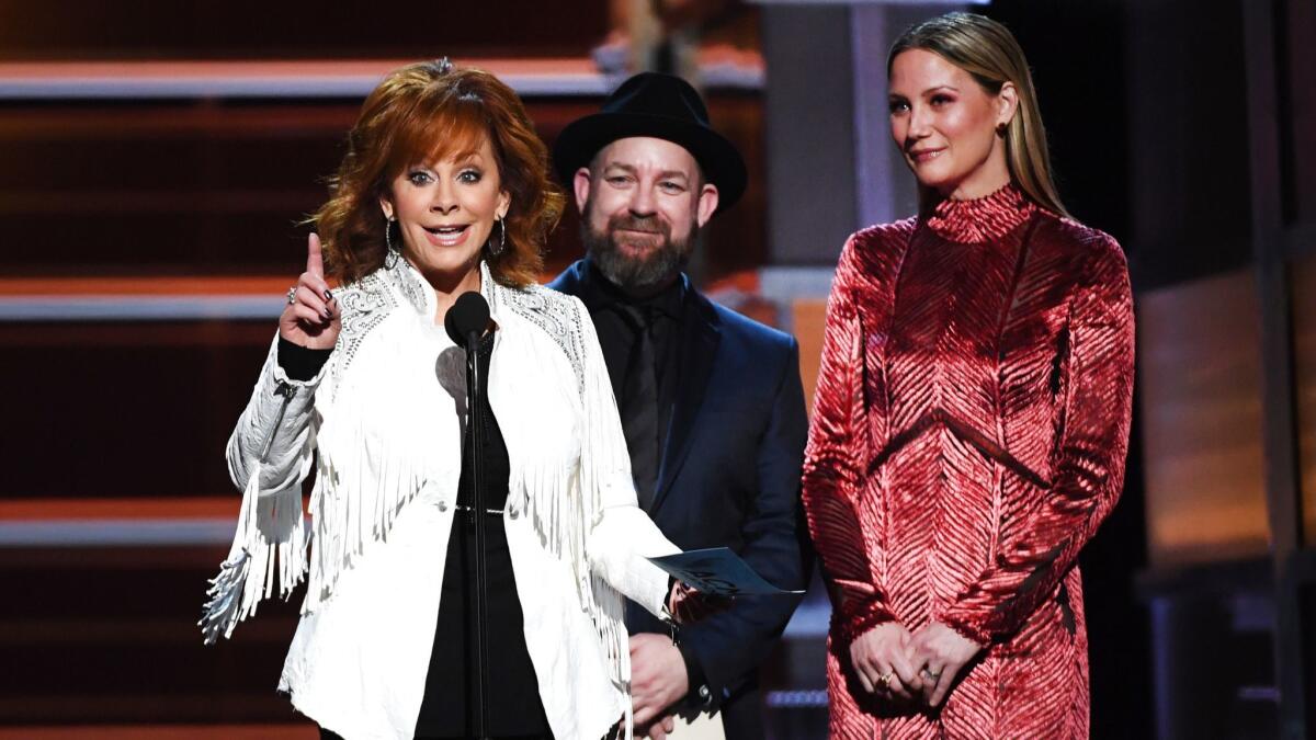 Host Reba McEntire, left, Kristian Bush and Jennifer Nettles speak onstage during the 53rd Academy of Country Music Awards at MGM Grand Garden Arena in Las Vegas.