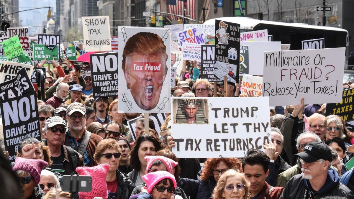 Marchers participate in a tax day protest on Saturday in New York City. Activists in cities across the nation are marching today to call on President Trump to release his tax returns.