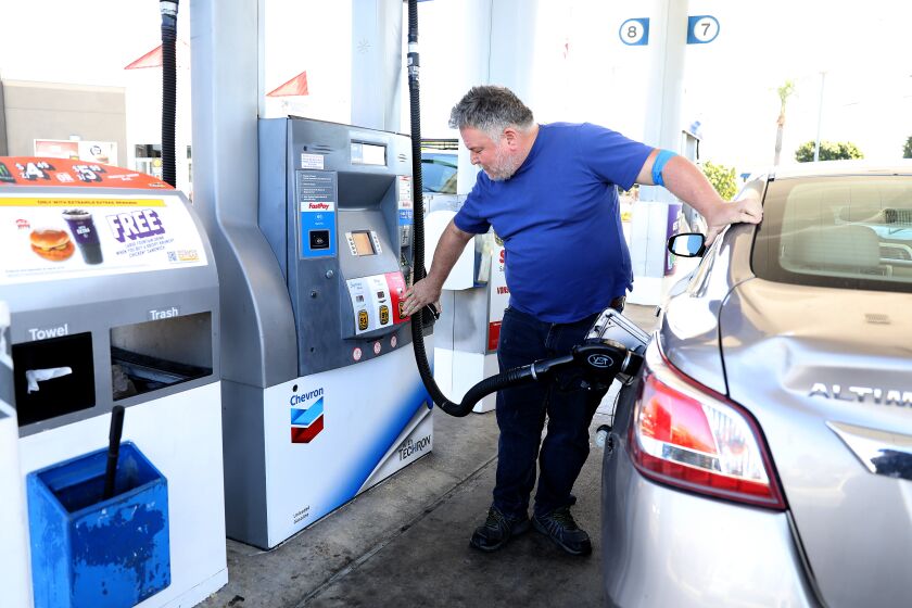 ORANGE, CA - MARCH 08: Joseph Starr, of Aliso Viejo, pumps gas into his automobile at the Chevron gas station along Katella Ave. and Glassell on Tuesday, March 8, 2022 in Orange, CA. Starr paid $15.60 for 2.766 gallons of regular gasoline. The average price of a gallon of self-serve regular gasoline in Los Angeles County rose 8.9 cents today, its 30th record in 32 days. In Orange County average price rose 8.8 cents, its 29th record in 34 days. (Gary Coronado / Los Angeles Times)