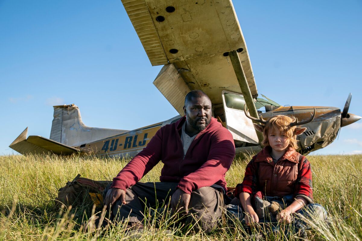 Jepperd and Gus sitting in grass near a plane
