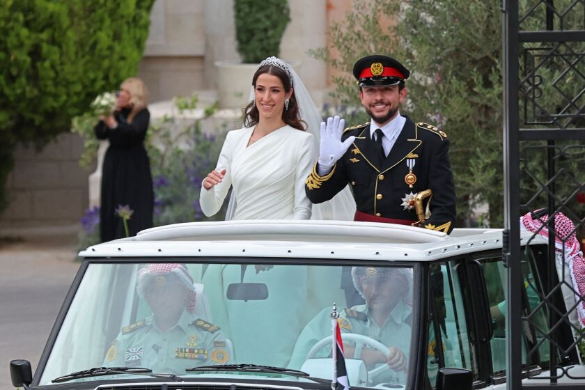Jordan's Crown Prince Hussein (R) and his wife Saudi Rajwa al-Seif wave as they leave the Zahran Palace in Amman on June 1, 2023 following their royal wedding ceremony. The ceremony was held in the mid-century Zahran Palace-- the site of other key royal weddings including that of King Abdullah II to Queen Rania as well as that of his father, the late King Hussein bin Talal. (Photo by Khalil MAZRAAWI / AFP) (Photo by KHALIL MAZRAAWI/AFP via Getty Images)