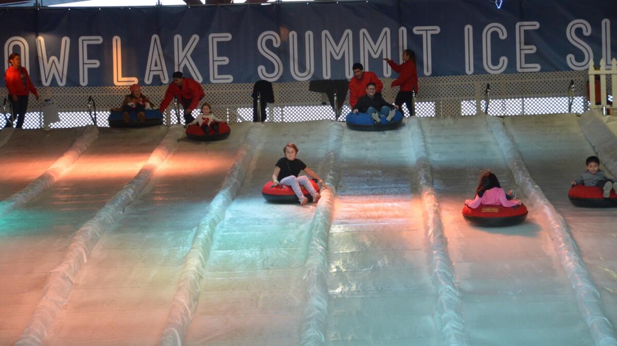 Kids go down the ice slide on inner tubes during Winter Fest at the OC Fair & Event Center in 2016.