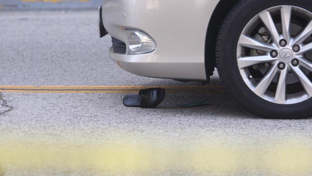 The shoe of the female victim remains near the front wheel of the car that struck her in Glendale on Friday, May 13, 2016. Before she was struck, Marieta Go had just been to the grocery store with her two friends, who were walking ahead of her in the crosswalk.