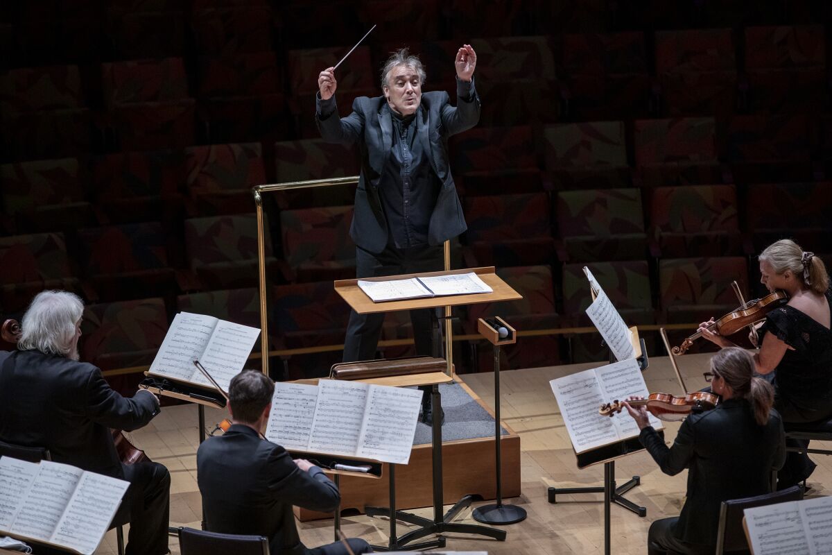 Los Angeles Chamber Orchestra musicians play as conductor Jaime Martín lifts his hands.