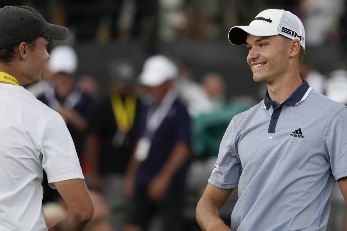Nicolai Hojgaard of Denmark, right, smiles at his twin brother Rasmus after winning the Italian Open golf tournament, in Guidonia, in the outskirts of Rome, Sunday, Sept. 5, 2021. The Italian Open took place on the redesigned Marco Simone course just outside Rome that will host the 2023 Ryder Cup.(AP Photo/Andrew Medichini)