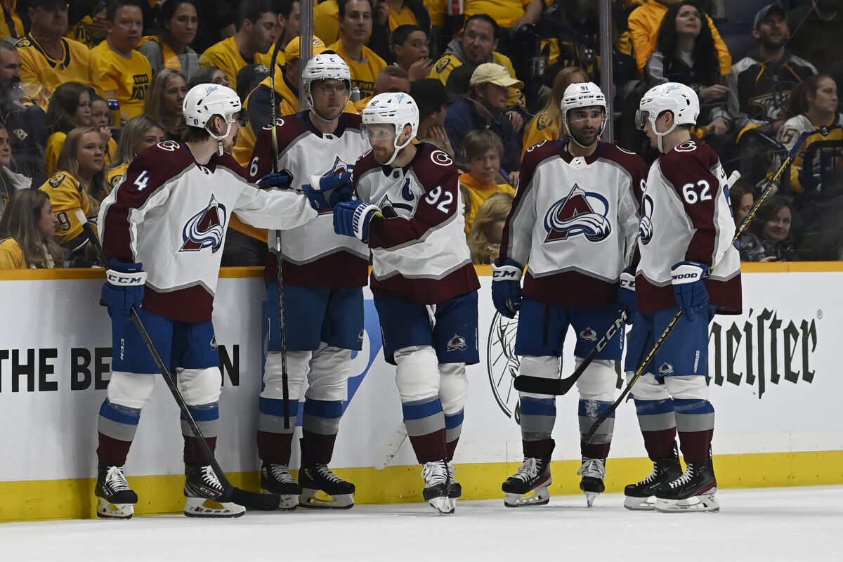 Colorado Avalanche left wing Gabriel Landeskog (92) is congratulated after scoring his third goal of the game during the second period in Game 3 of an NHL hockey Stanley Cup first-round playoff series against the Nashville Predators Saturday, May 7, 2022, in Nashville, Tenn. (AP Photo/Mark Zaleski)
