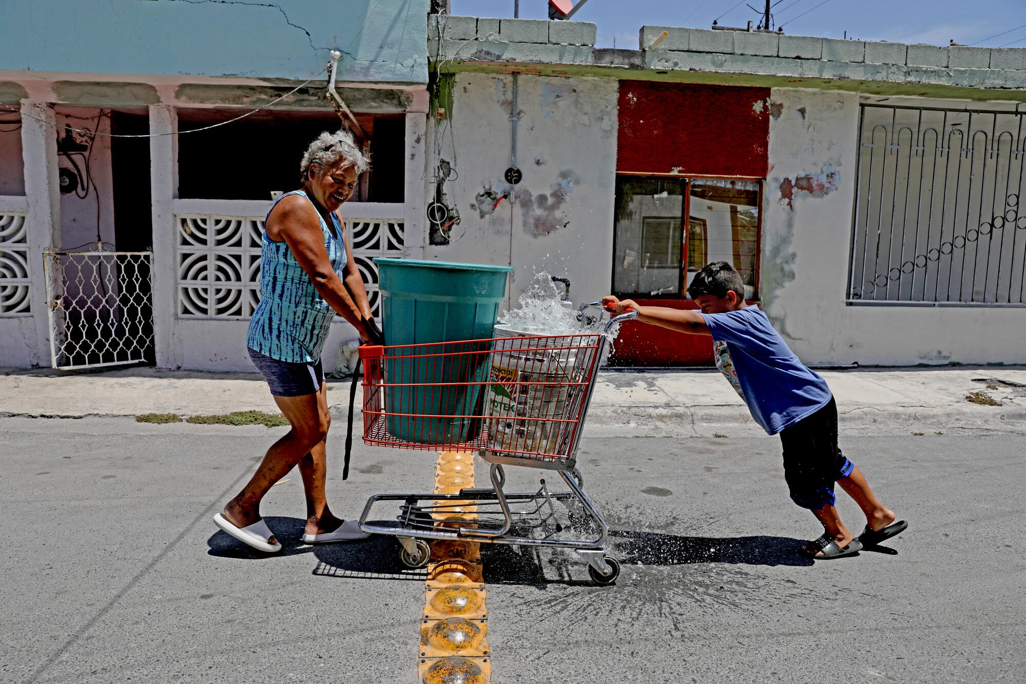 A woman and her grandson push a shopping cart